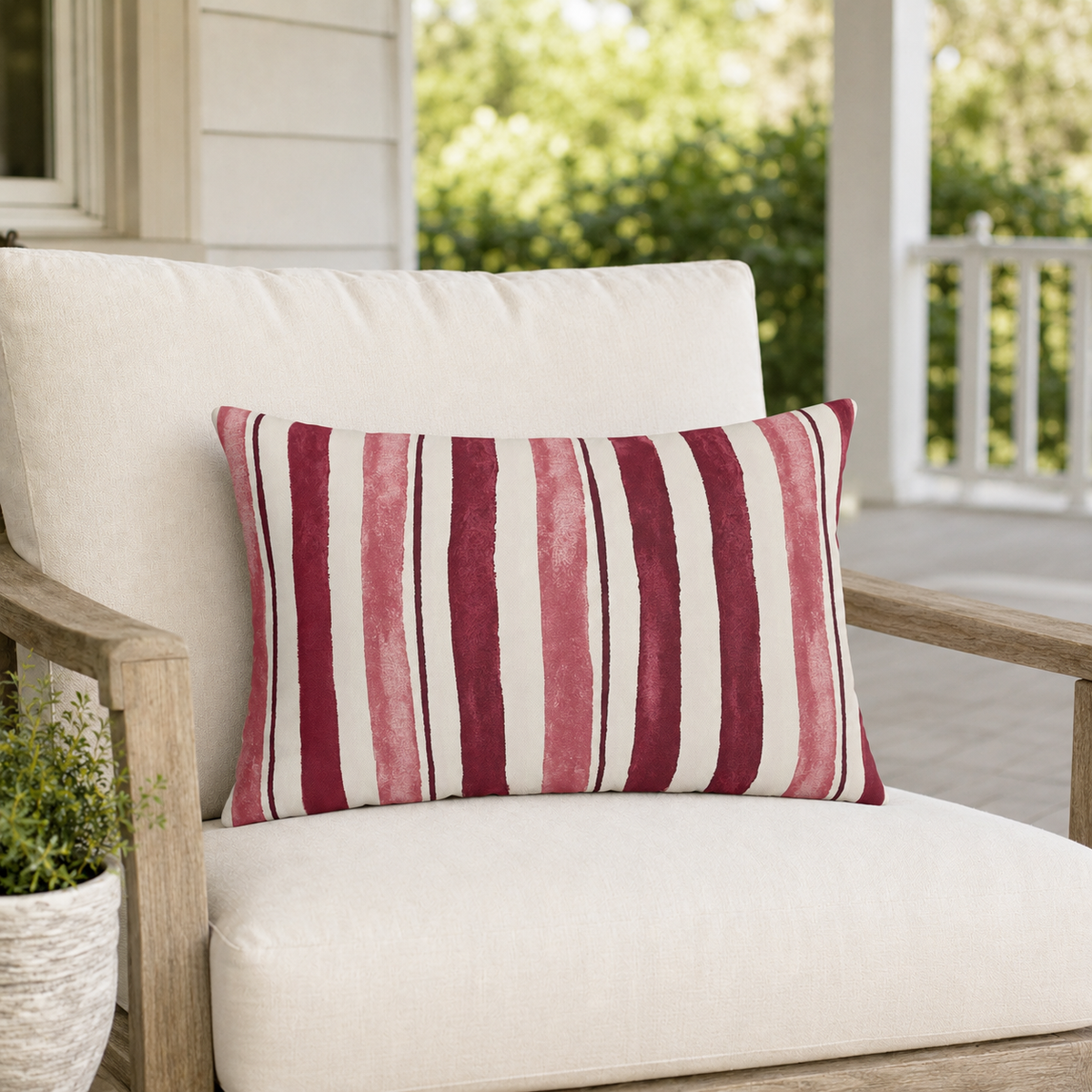 Cream outdoor lumbar pillow with cranberry and rose painted stripes, second view