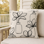 Cream outdoor pillow with black line-drawn plants and vases, second view