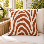 Rust zebra stripe outdoor pillow styled on patio furniture