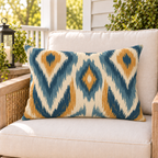 Blue and mustard ikat outdoor lumbar pillow styled on patio furniture