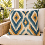 Blue and mustard ikat outdoor pillow styled on patio furniture