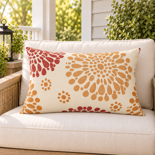 Rust and orange block print mum fall outdoor lumbar pillow styled on patio furniture