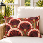 Red art deco fan flower outdoor lumbar pillow styled on patio furniture