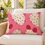 Pink prickly pear cactus outdoor lumbar pillow styled on patio furniture
