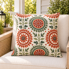 Terracotta and sage folk medallion outdoor pillow styled on patio furniture