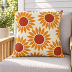 Orange retro sunflower outdoor pillow styled with matching pillows on a porch
