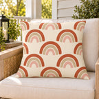 Boho rainbow arch outdoor pillow on a rattan chair on a sunny summer porch