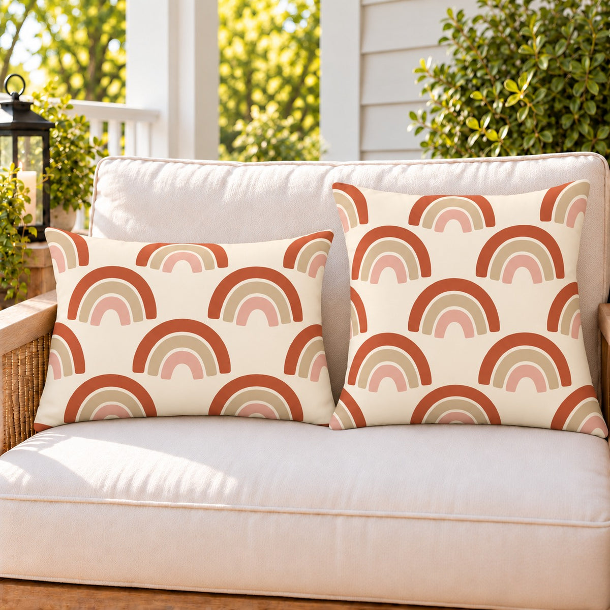 Boho rainbow arch outdoor pillow and outdoor lumbar pillow styled together as a set on a porch loveseat