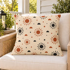 Boho sunburst outdoor pillow on a rattan chair on a sunny summer porch