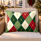 Green and red argyle outdoor lumbar pillow on a rattan chair on a snowy Christmas porch