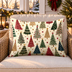 Cream Christmas trees outdoor lumbar pillow on a rattan chair on a snowy Christmas porch