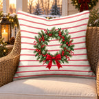 Red pinstripe Christmas wreath outdoor pillow on a rattan chair on a snowy Christmas porch