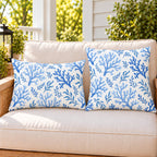 Blue coral coastal outdoor pillow and outdoor lumbar pillow styled together as a set on a porch loveseat