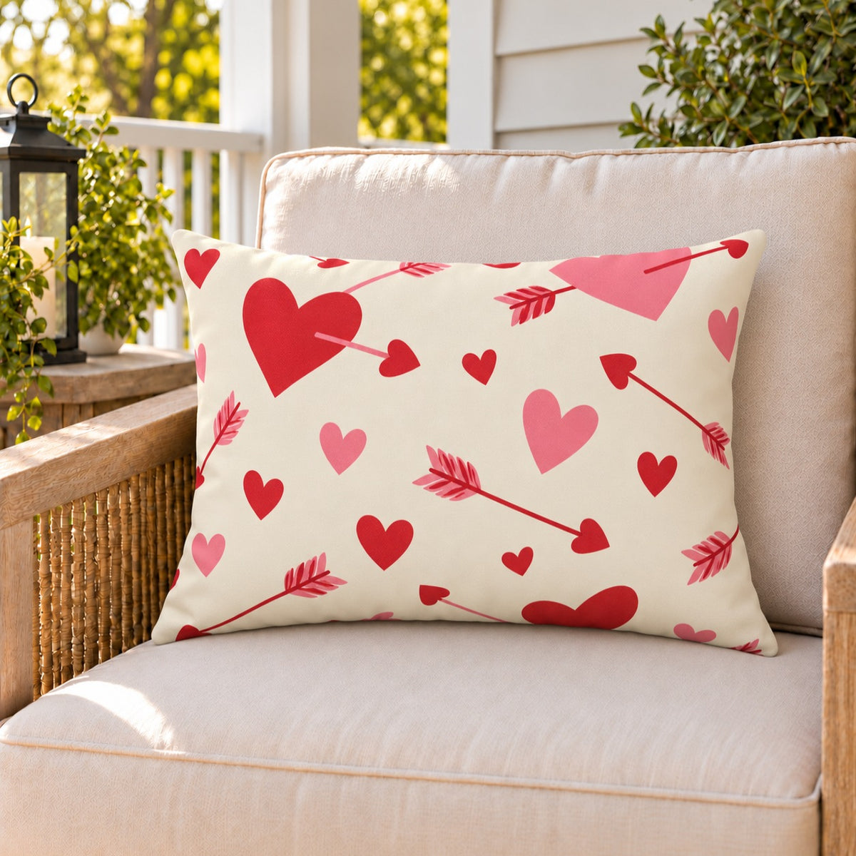 Cupid Arrow Red outdoor lumbar pillow on a rattan chair on a sunny summer porch