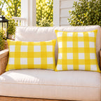 Yellow gingham check outdoor pillow and outdoor lumbar pillow styled together as a set on a porch loveseat