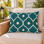 Teal Moroccan lantern outdoor lumbar pillow on a rattan chair on a sunny summer porch