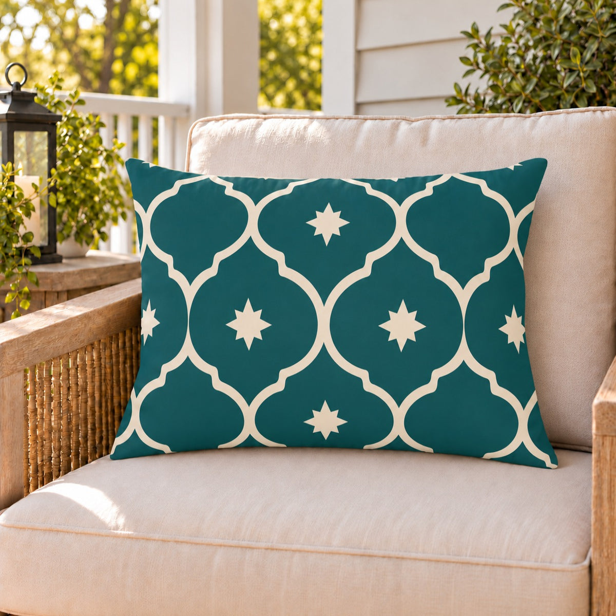 Teal Moroccan lantern outdoor lumbar pillow on a rattan chair on a sunny summer porch