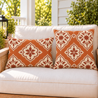 Moroccan Medallion Burnt Orange outdoor pillow and outdoor lumbar pillow styled together as a set on a porch loveseat