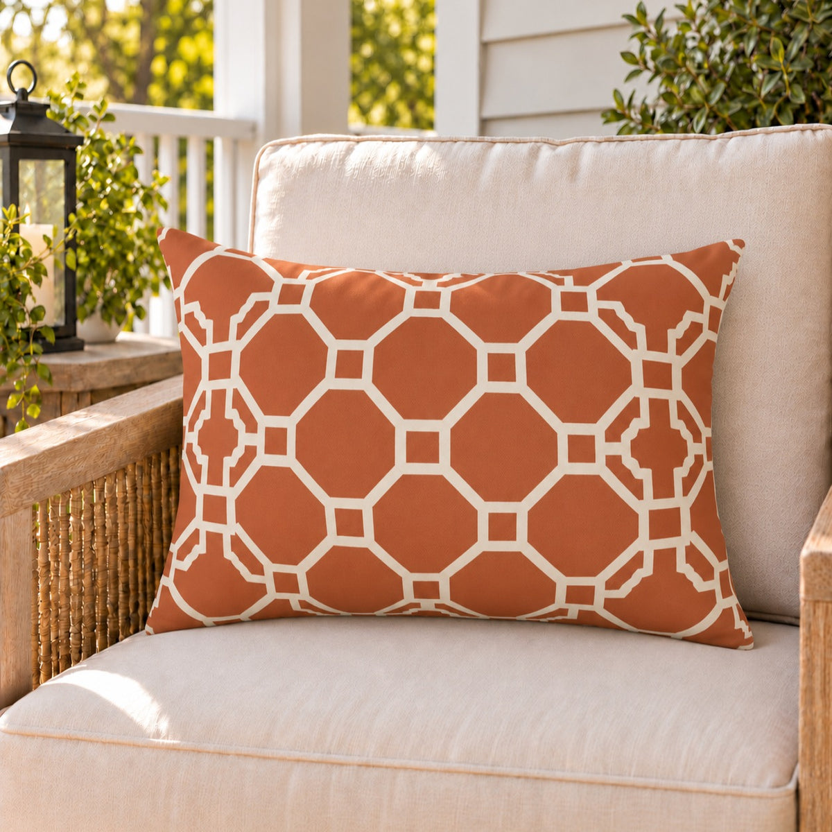 Moroccan Trellis Terracotta outdoor lumbar pillow on a rattan chair on a sunny summer porch