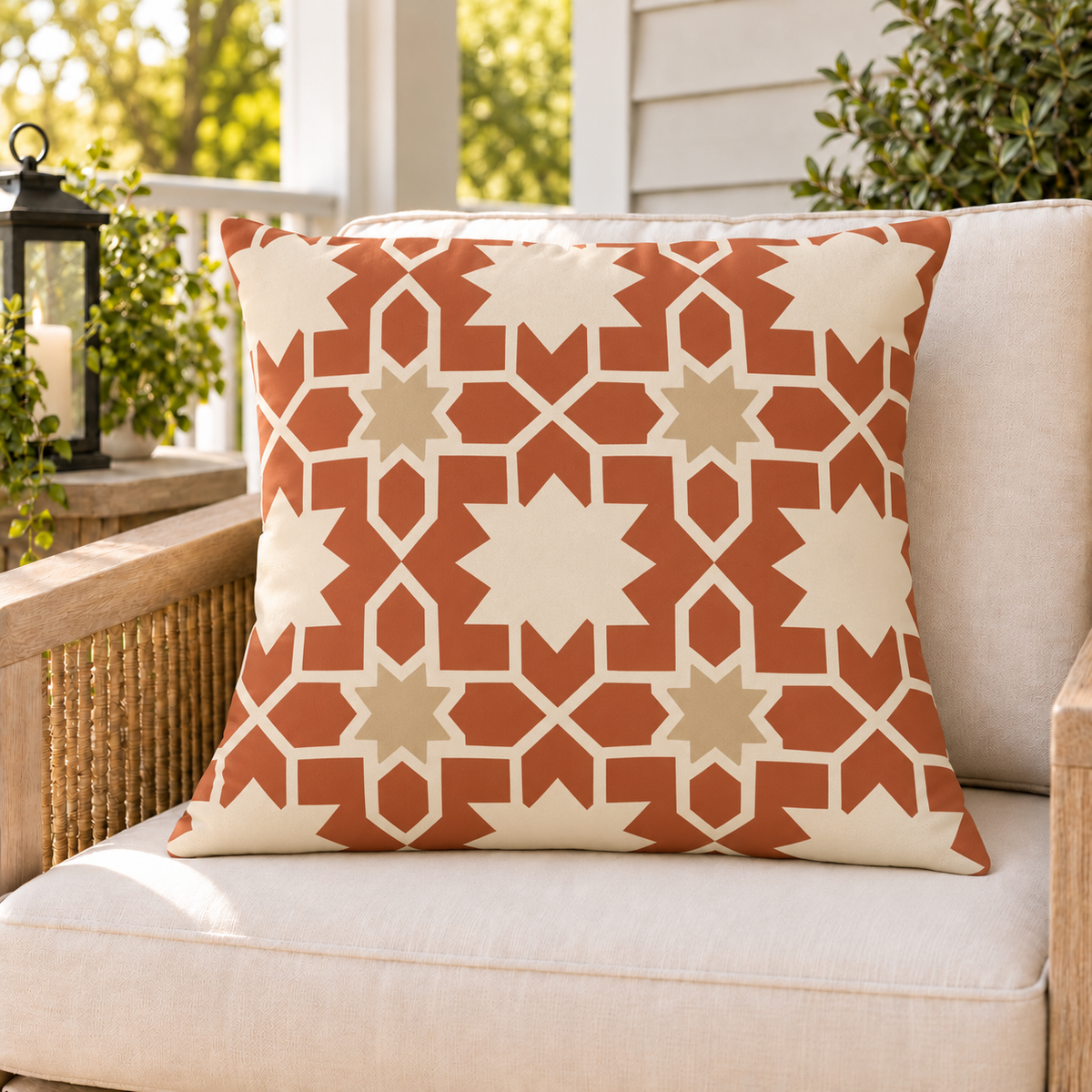 Moroccan Zellige Star Terracotta outdoor pillow on a rattan chair on a sunny summer porch