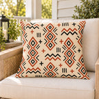 Terracotta mudcloth boho outdoor pillow on a rattan chair on a sunny summer porch