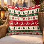 Red Nordic reindeer outdoor pillow on a rattan chair on a snowy Christmas porch