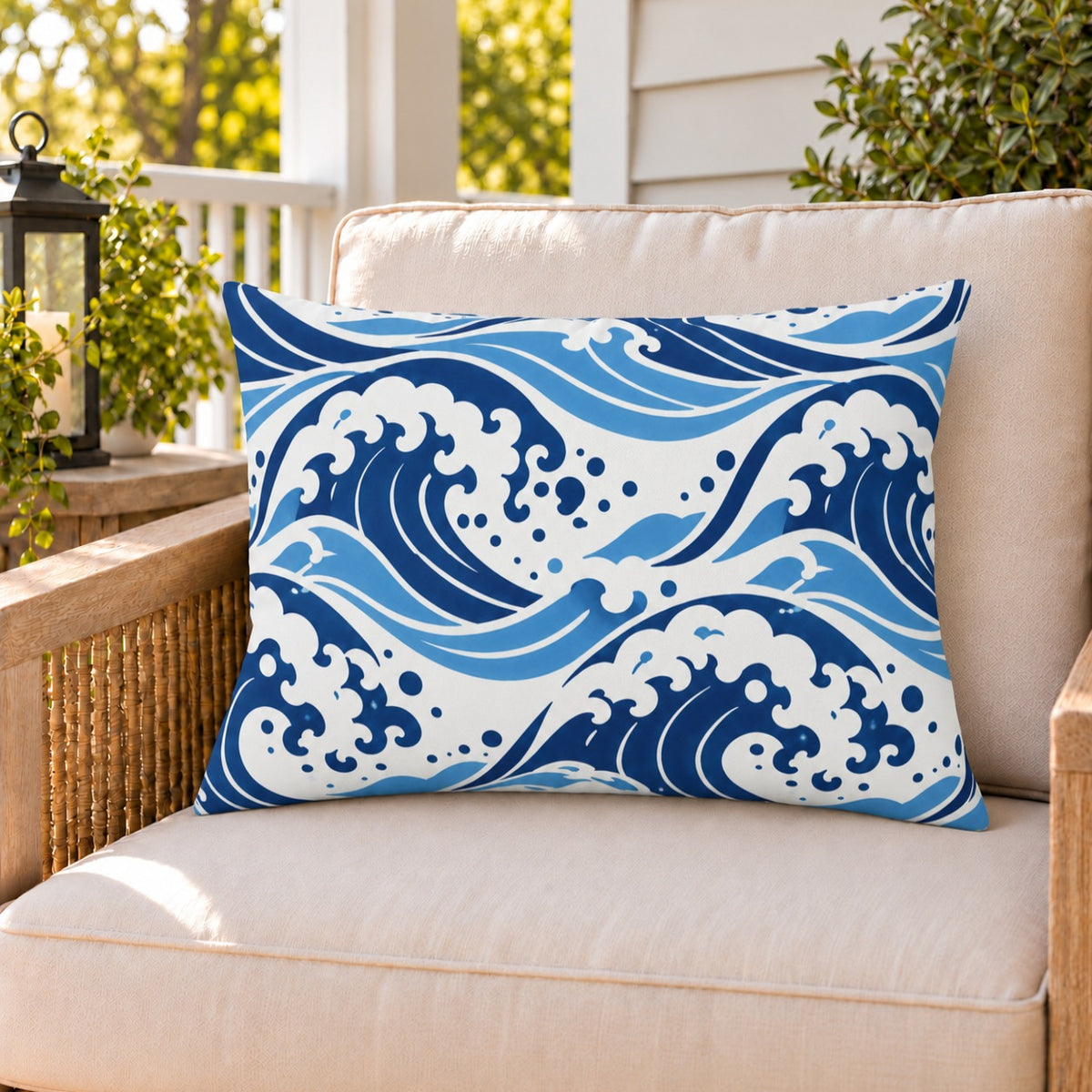 Navy ocean wave outdoor lumbar pillow on a rattan chair on a sunny summer porch