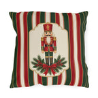 Vintage Christmas nutcracker outdoor pillow with a framed nutcracker soldier, pine and a red bow on red, green and cream stripes