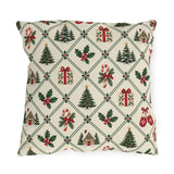 Christmas village outdoor pillow with a green lattice of pine trees, holly, mittens, gifts and cottages on cream