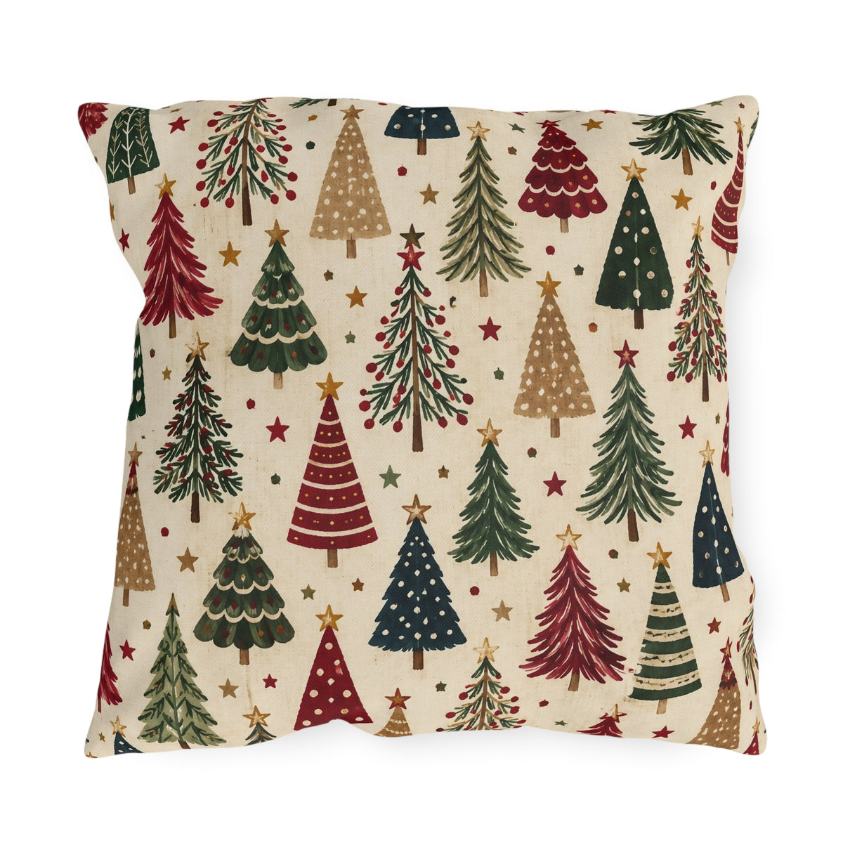 Christmas tree outdoor pillow with a scatter of red, green, navy and tan Christmas trees and gold stars on cream