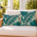 Teal palm frond outdoor pillow and outdoor lumbar pillow styled together as a set on a porch loveseat