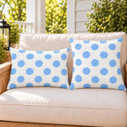 Light blue polka dot outdoor pillow and outdoor lumbar pillow styled together as a set on a porch loveseat