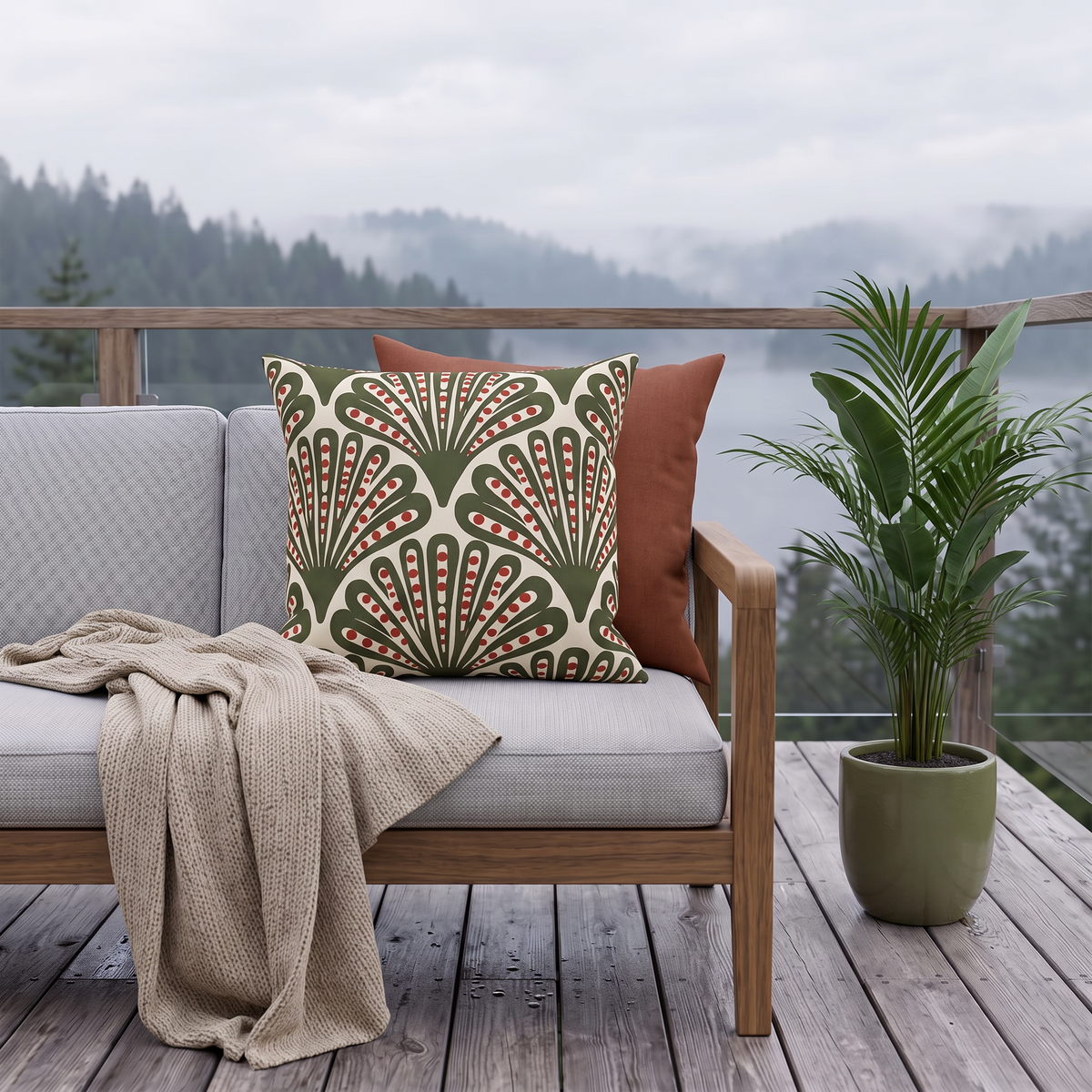 Green and red dotted fan outdoor pillow styled on a porch