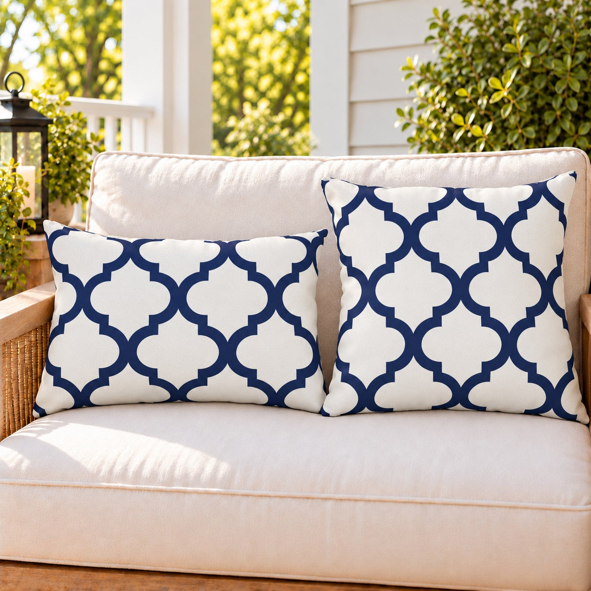 Navy quatrefoil outdoor pillow and outdoor lumbar pillow styled together as a set on a porch loveseat
