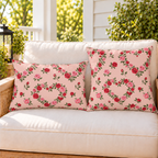 Rose Heart Blush outdoor pillow and outdoor lumbar pillow styled together as a set on a porch loveseat