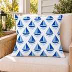 Blue sailboat outdoor pillow on a rattan chair on a sunny summer porch